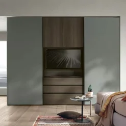 Armadio ante scorrevoli con vano TV girevole con cassetti e maniglia a gola disponibile in vari colori